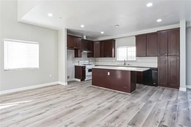 a kitchen with stainless steel appliances granite countertop a refrigerator and a stove top oven