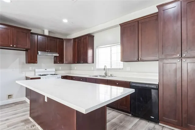 a kitchen with a sink a stove a kitchen island and cabinetry