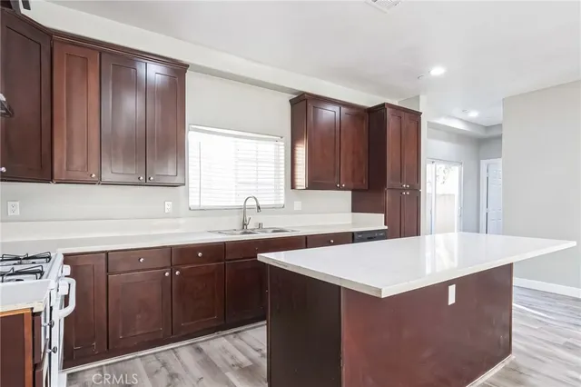 a kitchen with a sink a cabinets and wooden floor