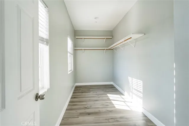 a view of a hallway with wooden floor and a white door