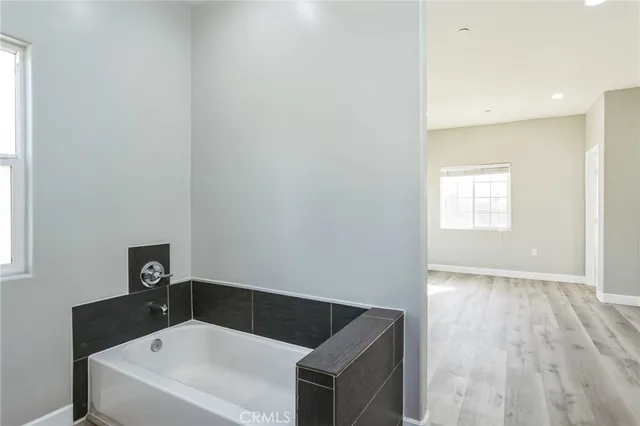 a bathroom with a bathtub and a window