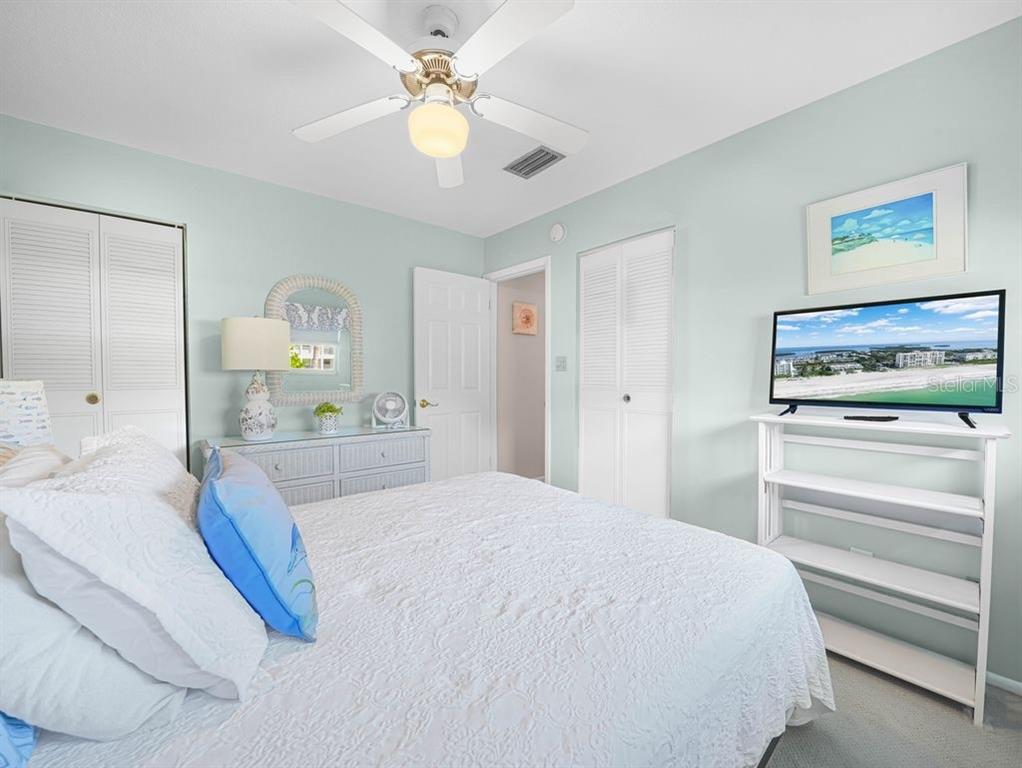 549 Sutton Place, Unit T 19 Longboat Key, FL 34228 - Photo 12 of 52 a bedroom with a bed and a chandelier