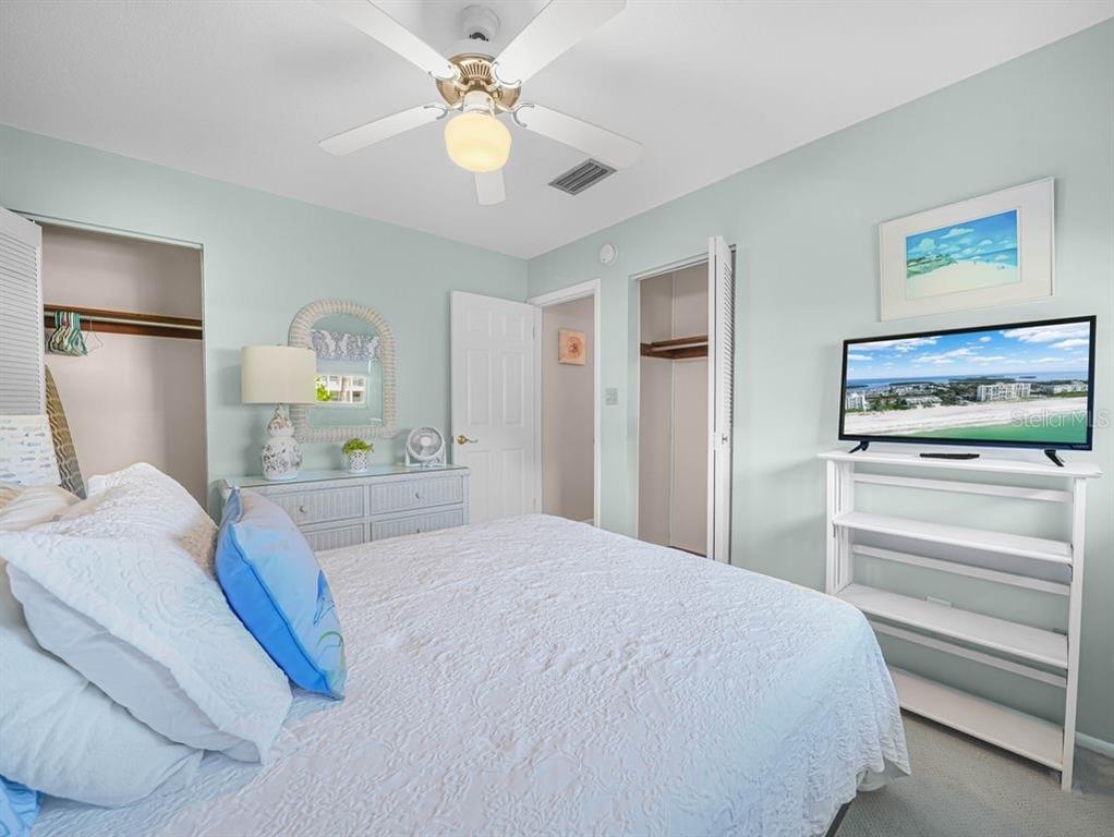 549 Sutton Place, Unit T 19 Longboat Key, FL 34228 - Photo 13 of 52 a bedroom with a bed and a chandelier