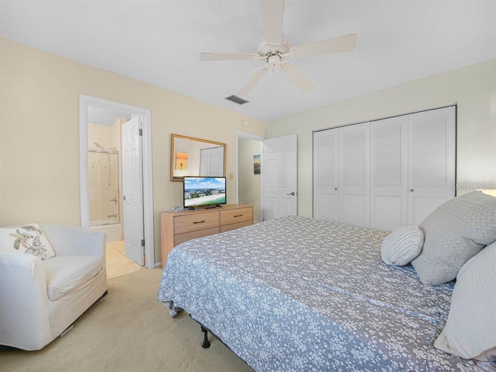 549 Sutton Place, Unit T 19 Longboat Key, FL 34228 - Photo 16 of 52 a spacious bedroom with a bed and a couch