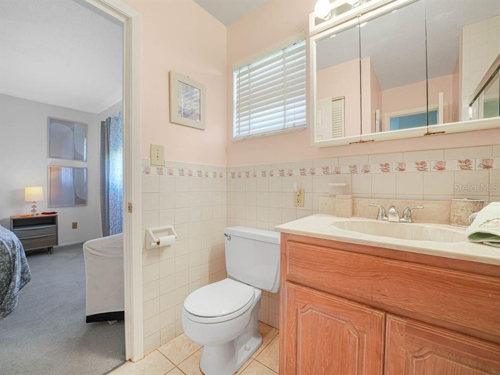 549 Sutton Place, Unit T 19 Longboat Key, FL 34228 - Photo 18 of 52 a bathroom with a sink a toilet and a mirror