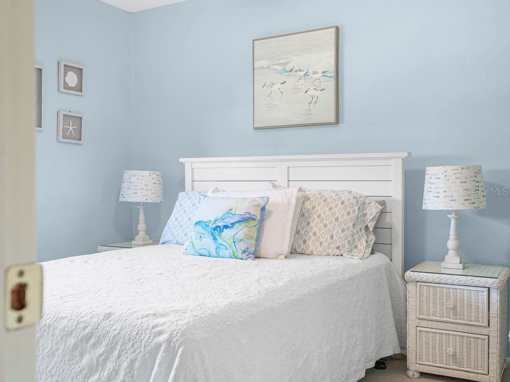 549 Sutton Place, Unit T 19 Longboat Key, FL 34228 - Photo 20 of 52 a bedroom with a bed and a painting on the wall