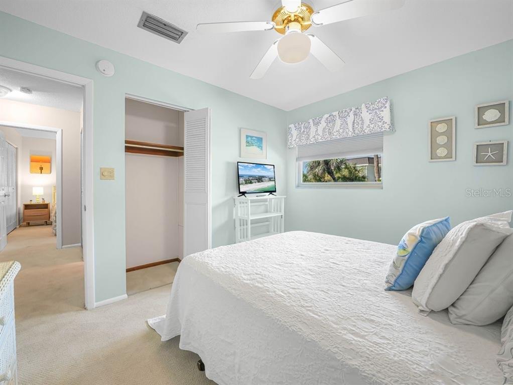 549 Sutton Place, Unit T 19 Longboat Key, FL 34228 - Photo 21 of 52 a bedroom with a bed and a chandelier