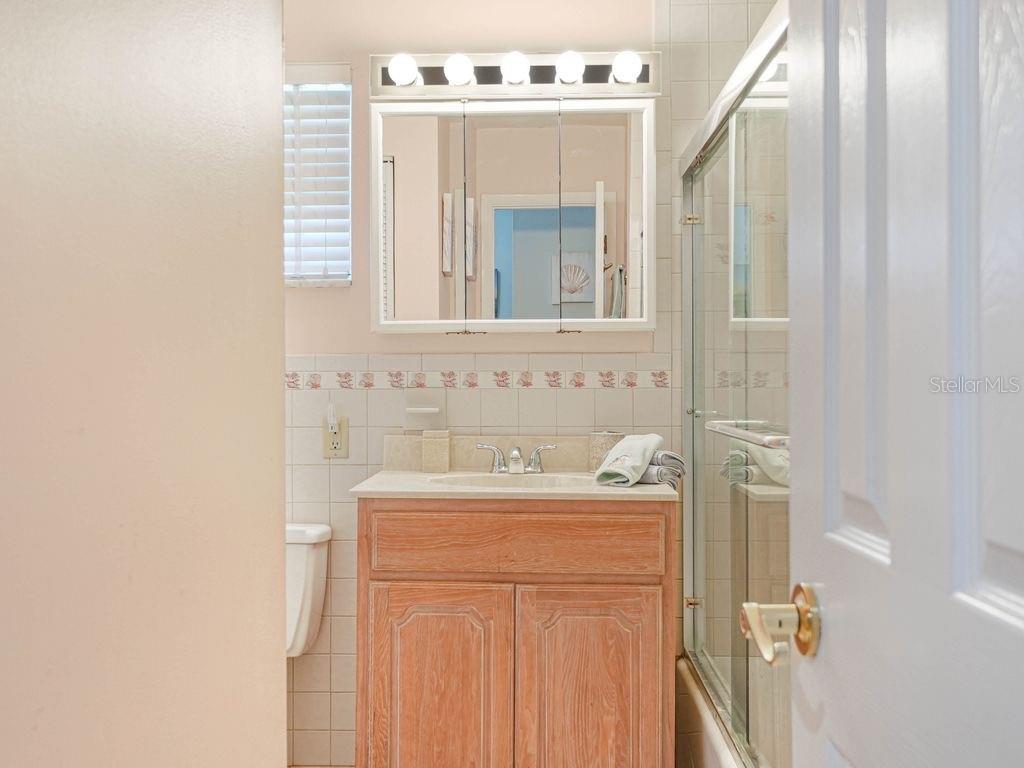 549 Sutton Place, Unit T 19 Longboat Key, FL 34228 - Photo 22 of 52 a bathroom with a sink a vanity and a mirror