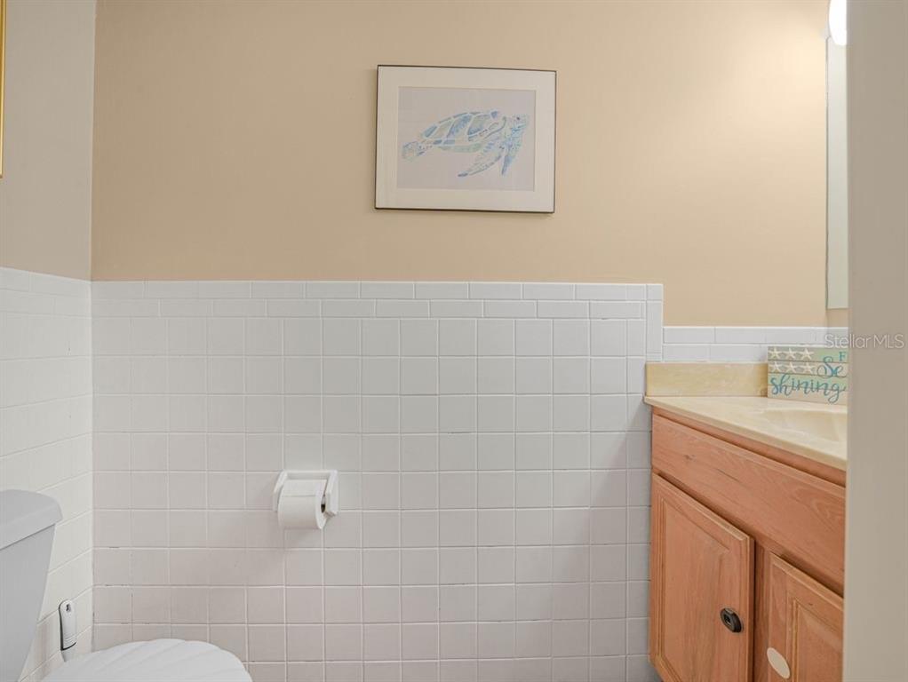 549 Sutton Place, Unit T 19 Longboat Key, FL 34228 - Photo 24 of 52 a bathroom with a granite countertop sink a toilet and a shower