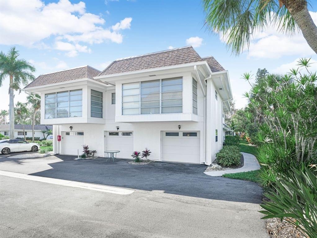 549 Sutton Place, Unit T 19 Longboat Key, FL 34228 - Photo 32 of 52 a front view of a house with a yard and garage
