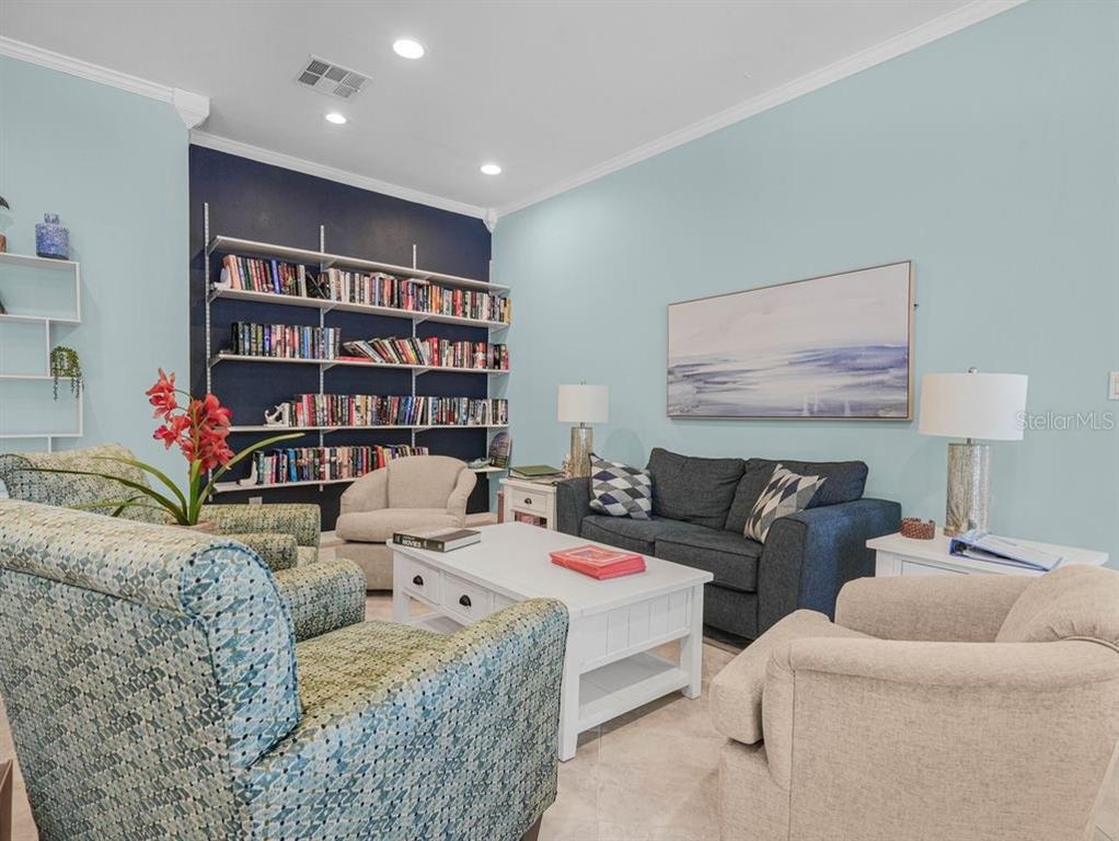549 Sutton Place, Unit T 19 Longboat Key, FL 34228 - Photo 39 of 52 a living room with furniture and a book shelf