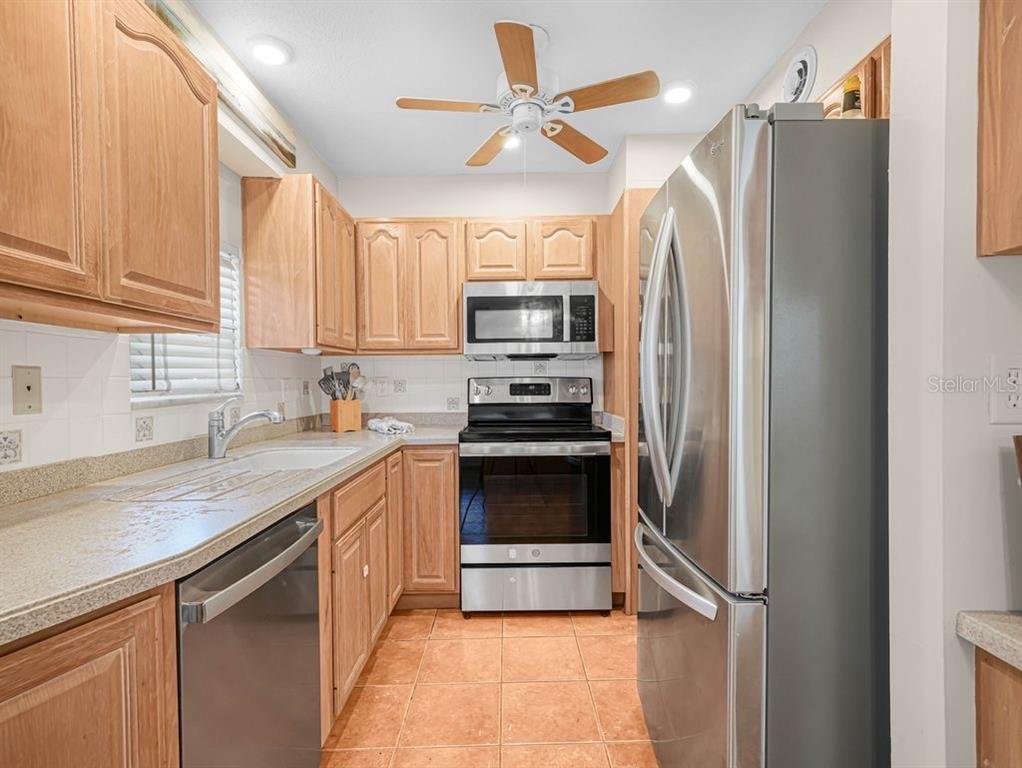 549 Sutton Place, Unit T 19 Longboat Key, FL 34228 - Photo 7 of 52 a kitchen with stainless steel appliances granite countertop a refrigerator and a sink