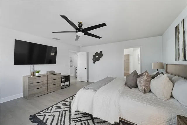 a bedroom with a bed tv and flat screen tv