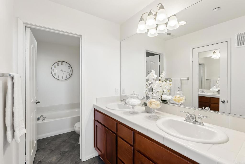 1276 San Elijo Road North San Marcos, CA 92078 - Photo 12 of 35 a bathroom with a granite countertop sink a large mirror and a shower