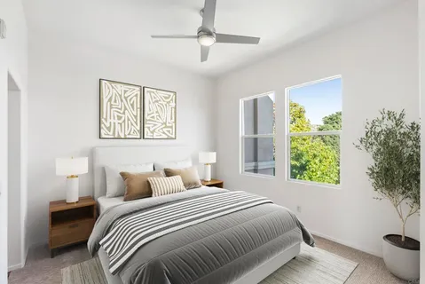 a bedroom with a bed and a lamp on the dresser