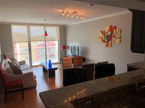 a living room with furniture potted plant on the coffee table and a large window