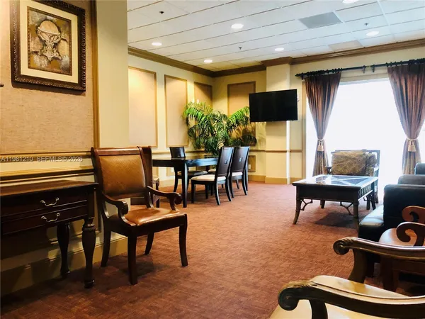 a living room with furniture a flat screen tv and a window