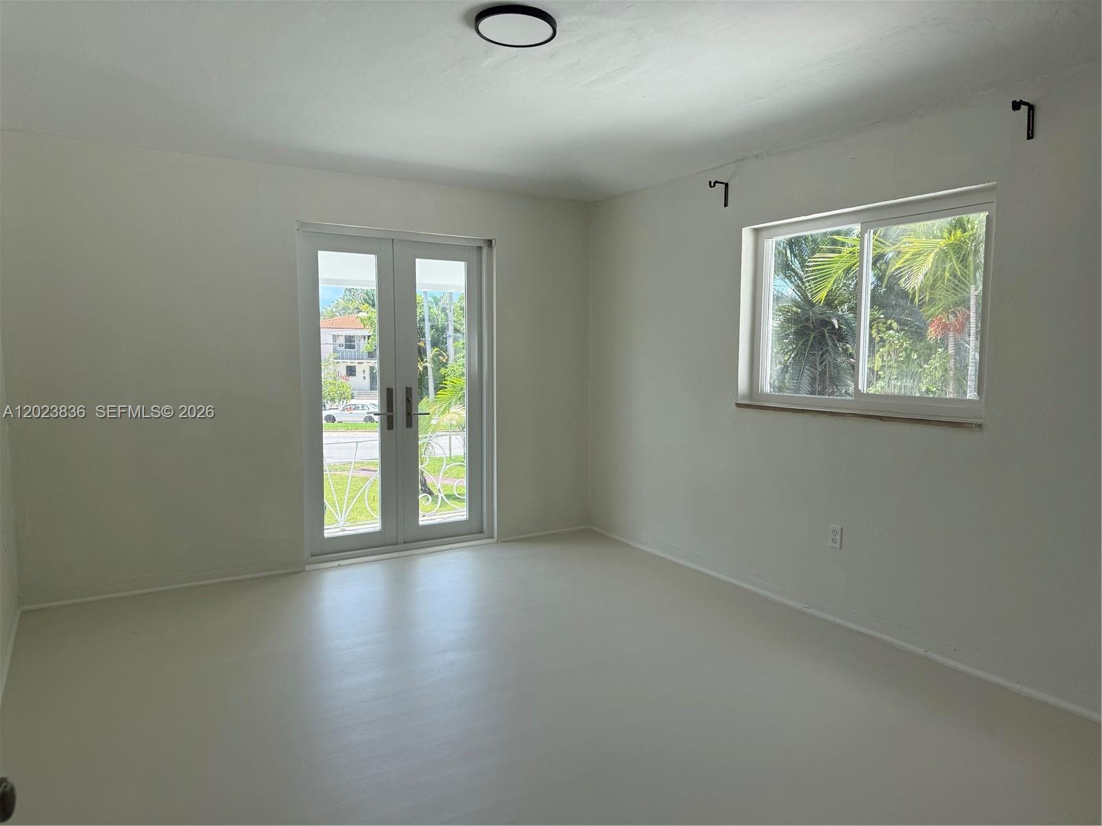 6312 Alton Road Miami Beach, FL 33140 - Photo 3 of 15 an empty room with wooden floor and windows