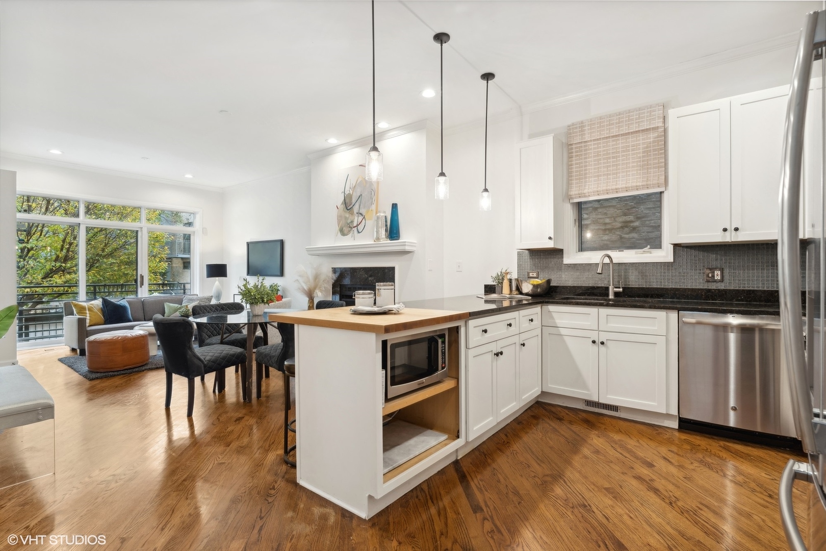 1372 North Dean Street, Unit 1 Chicago, IL 60622 - Photo 6 of 26 a kitchen with a stove top oven a sink dishwasher a dining table and chairs with wooden floor