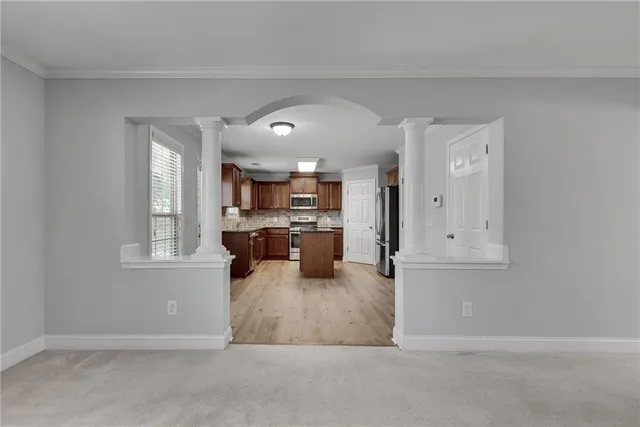 a kitchen with a refrigerator and wooden cabinets