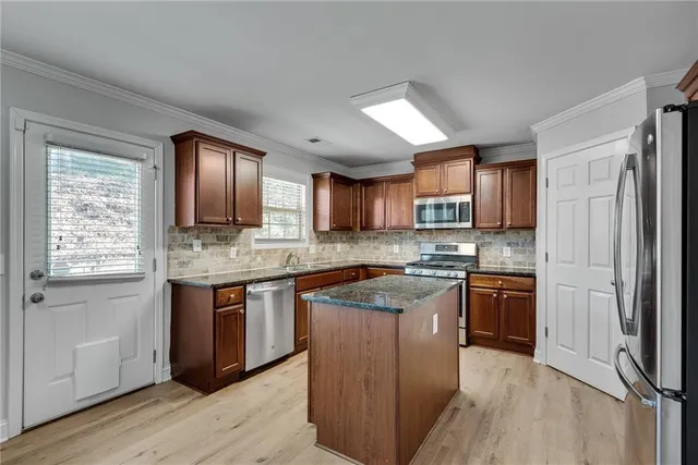 a large kitchen with kitchen island a sink granite counter tops and a view of living room