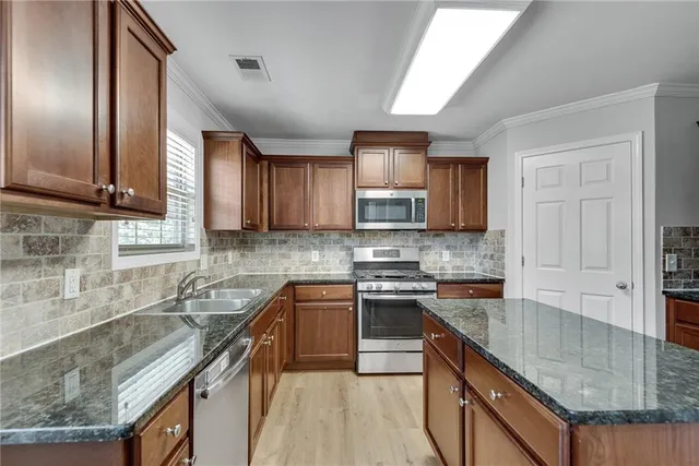 a kitchen with stainless steel appliances granite countertop a refrigerator stove and microwave
