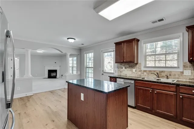 a kitchen with stainless steel appliances granite countertop a refrigerator stove and sink