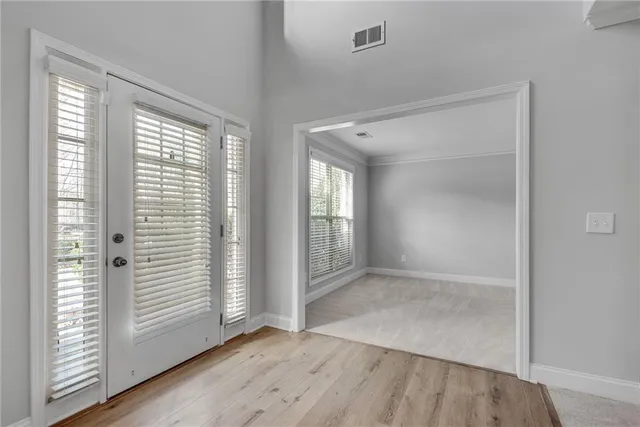an empty room with wooden floor and windows
