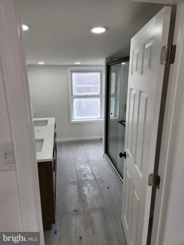 a bathroom with a double vanity sink and glass door