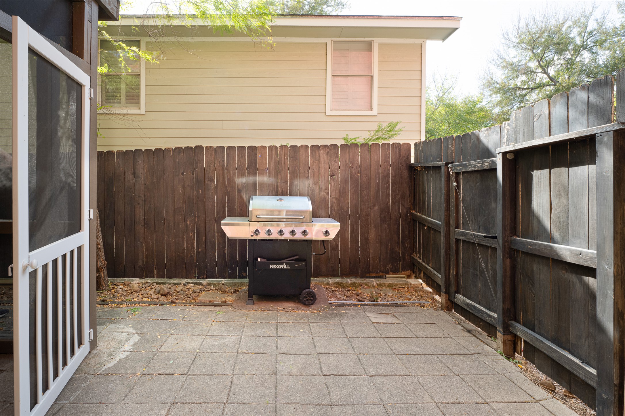2302 East 9th Street Austin, TX 78702 - Photo 27 of 31 A compact patio offers an ideal space for outdoor entertaining with a convenient grill and privacy fencing.