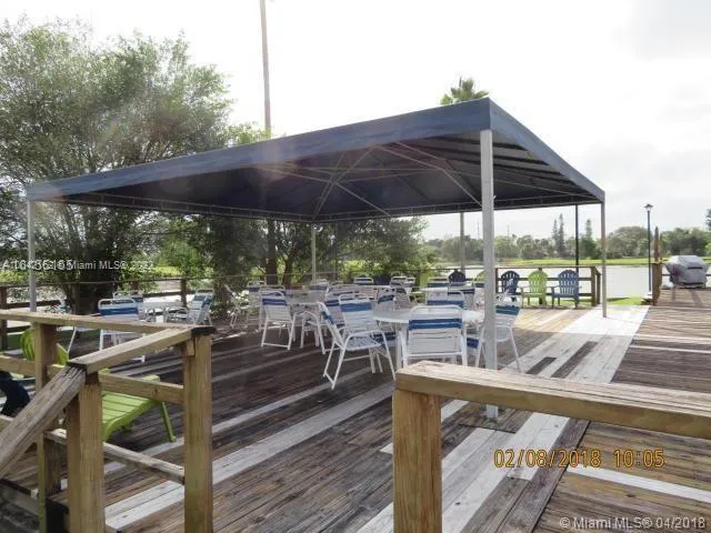 a view of a patio with chairs and table under an umbrella