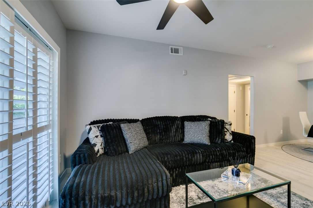 7255 West Sunset Road, Unit 1103 Las Vegas, NV 89113 - Photo 14 of 35 A well-lit living area with a vaulted ceiling and rich flooring offers comfortable living.