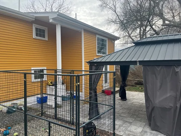 a view of backyard with small cabin and wooden fencing