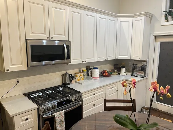 a kitchen with stainless steel appliances a stove a microwave and a cabinets
