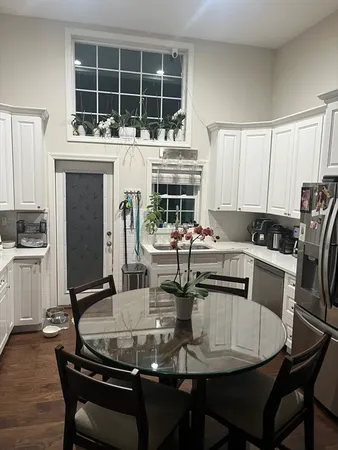 a dining room with furniture a rug and kitchen view