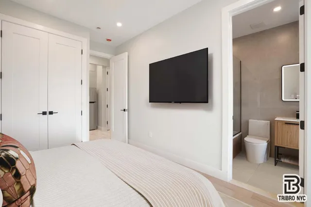 a bedroom with a bed and a flat screen tv