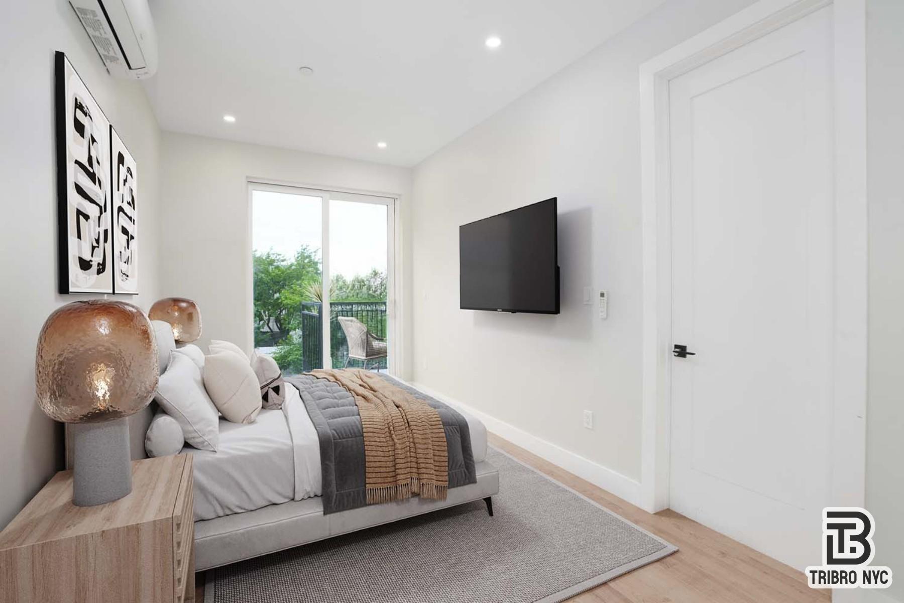 92 Manhattan Avenue, Unit 1B Brooklyn, NY 11206 - Photo 5 of 9 a bedroom with a bed and a flat tv screen