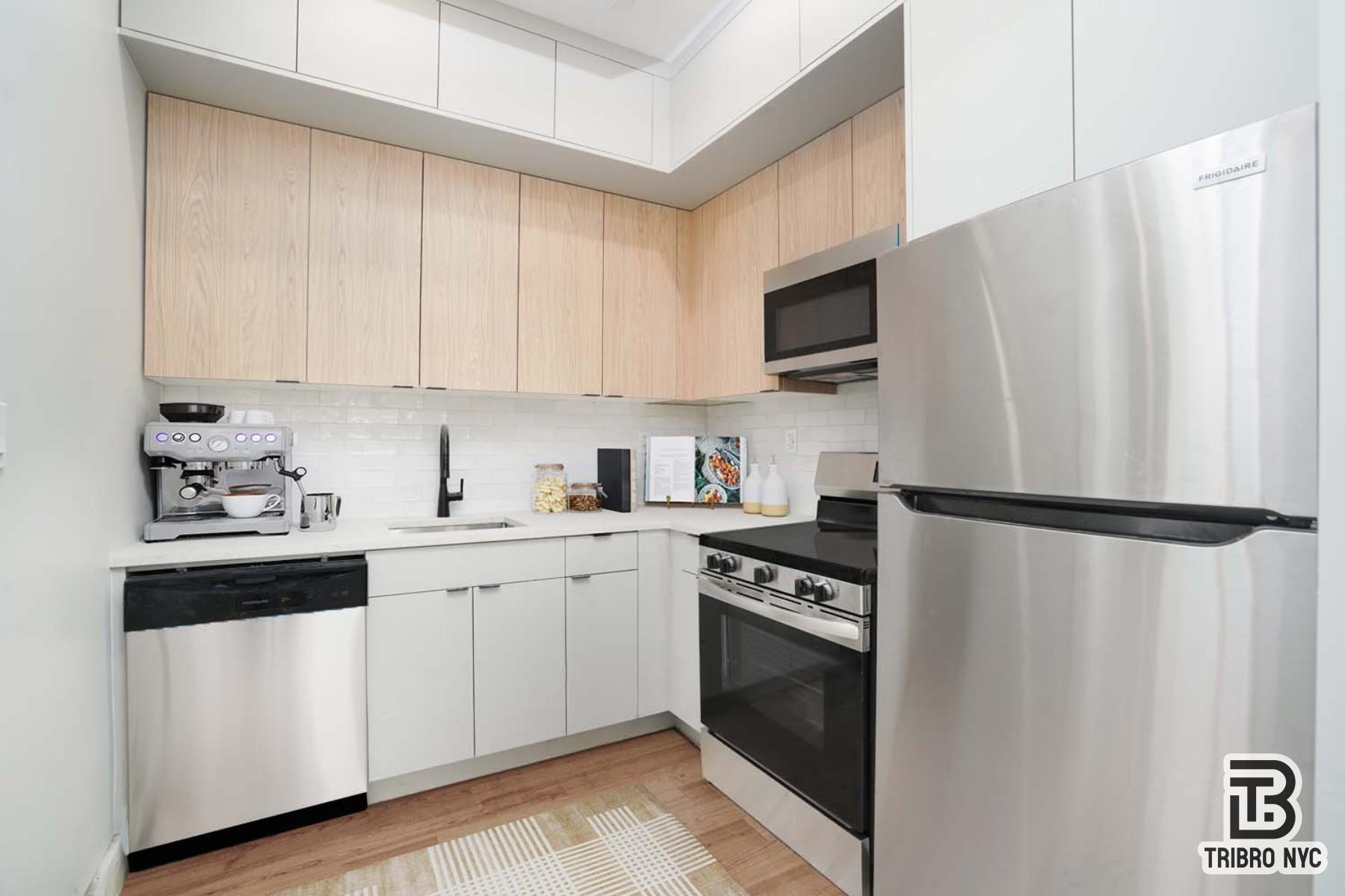 92 Manhattan Avenue, Unit 1B Brooklyn, NY 11206 - Photo 6 of 9 a kitchen with a refrigerator sink and white cabinets