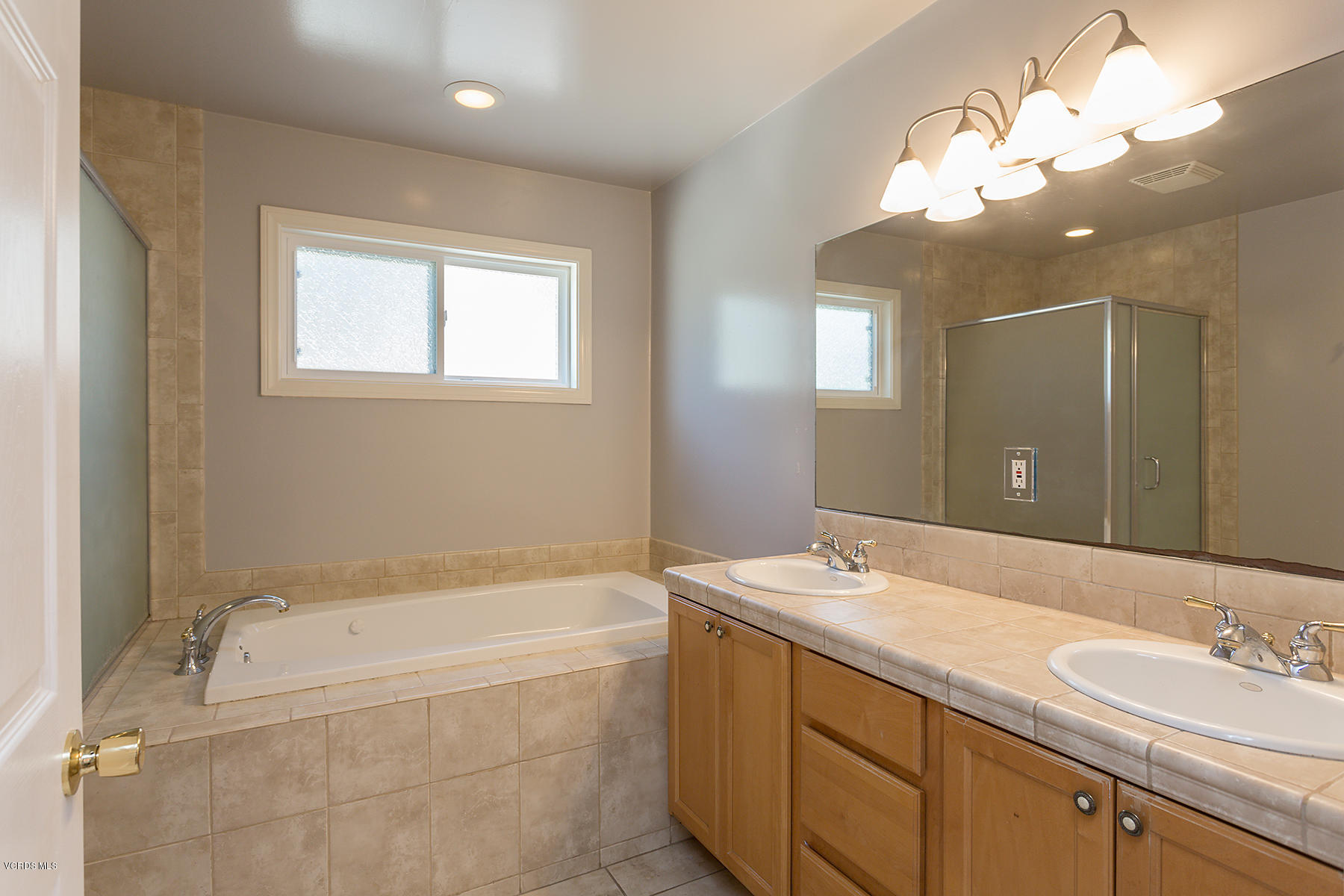 931 Walnut Canyon Road Moorpark, CA 93021 - Photo 12 of 27 a bathroom with a tub a sink and mirror
