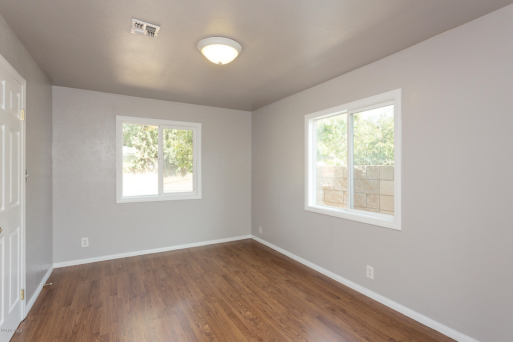 931 Walnut Canyon Road Moorpark, CA 93021 - Photo 6 of 27 an empty room with wooden floor and windows