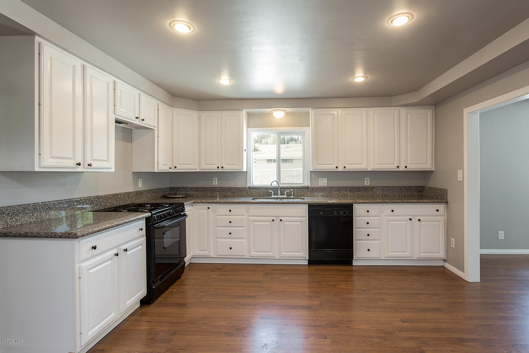 931 Walnut Canyon Road Moorpark, CA 93021 - Photo 8 of 27 a kitchen with granite countertop white cabinets stainless steel appliances a sink and a window