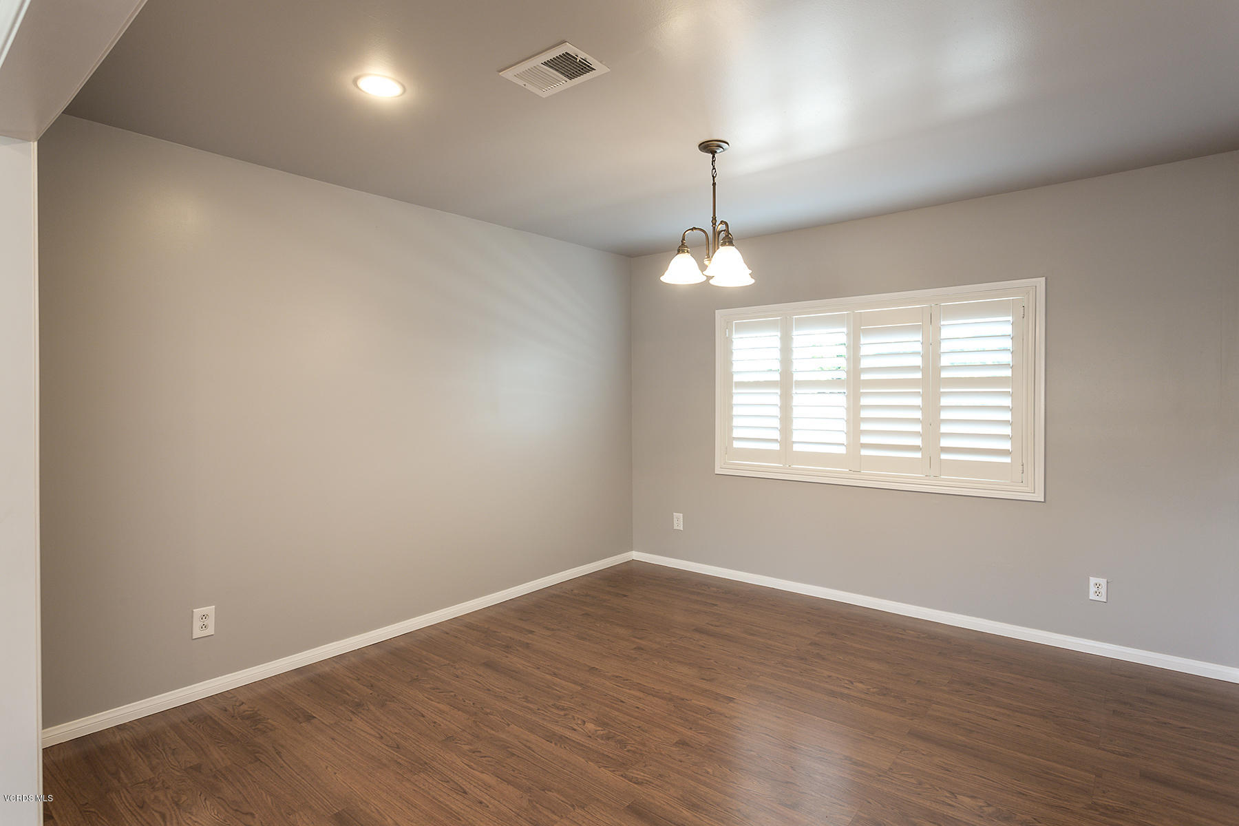 931 Walnut Canyon Road Moorpark, CA 93021 - Photo 9 of 27 an empty room with wooden floor chandelier and windows