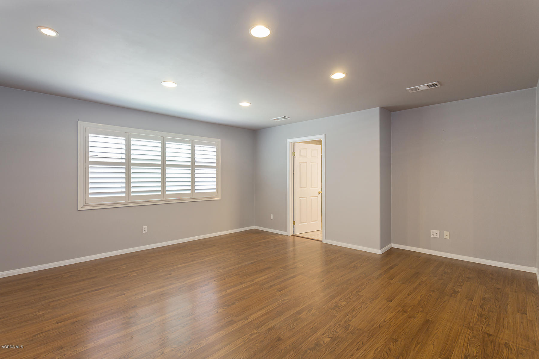 931 Walnut Canyon Road Moorpark, CA 93021 - Photo 10 of 27 an empty room with wooden floor and windows