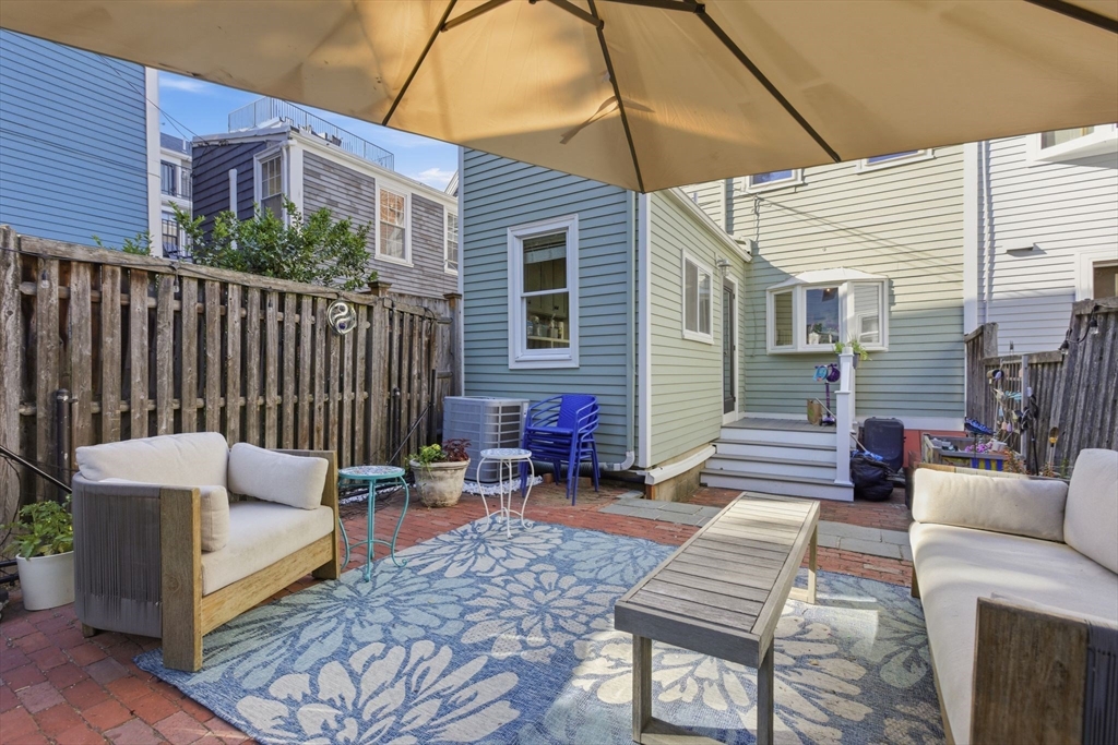 38 Bartlett Street Boston, MA 02129 - Photo 12 of 37 a view of a patio with a dining table and chairs with wooden fence