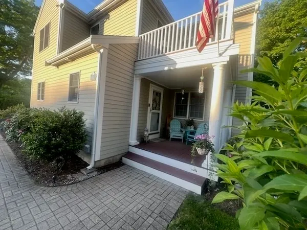a view of a house with chairs and potted plants