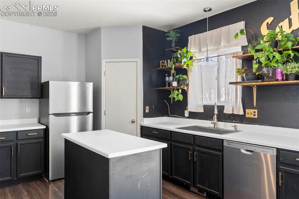 7509 Sistine Lane Fountain, CO 80817 - Photo 11 of 22 a kitchen with stainless steel appliances kitchen island a refrigerator sink and wooden floor