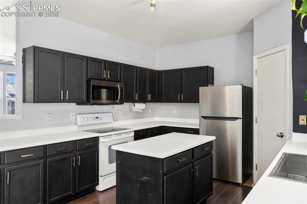 7509 Sistine Lane Fountain, CO 80817 - Photo 12 of 22 a kitchen with a sink a stove a refrigerator and a microwave