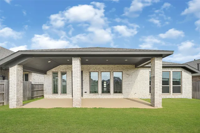 a view of a house with a big yard and large trees