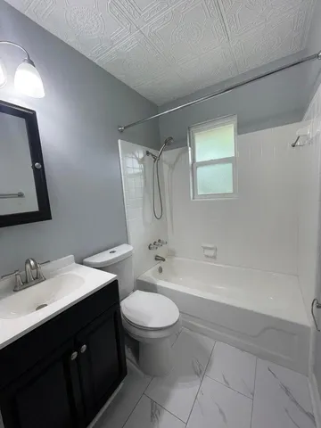 a bathroom with a double vanity sink toilet mirror and bathtub