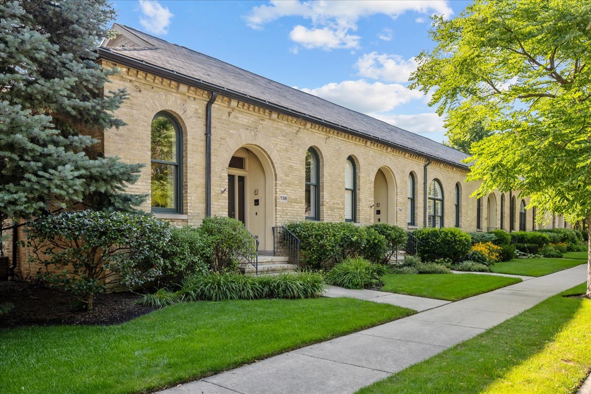 a front view of a house with garden and trees